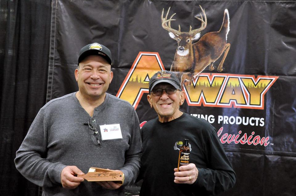 Greg Abbas (left), and his father, Fred, show off some of their turkey and deer hunting products at their Away Hunting Products booth at this past weekend’s Northeast Ohio Sportsman Show in Mount Hope. Greg and Fred Abbas also gave talks on turkey hunting and deer hunting at the show.