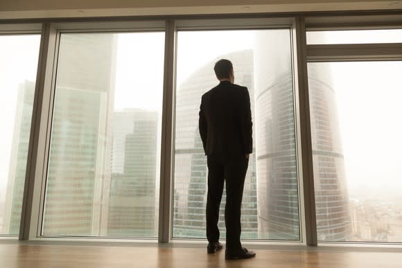 Businessman looking out window at skyscrapers