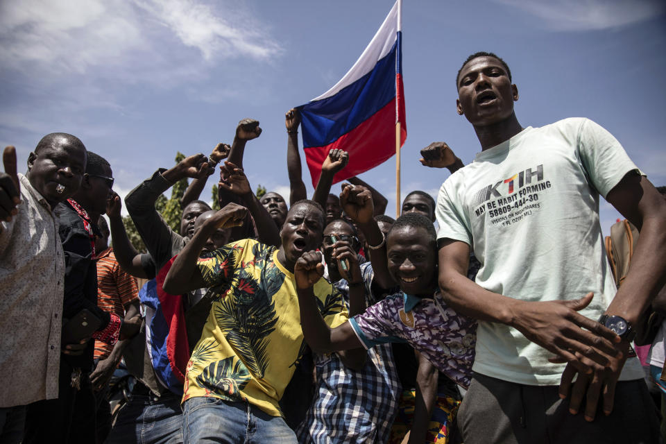 Young men chant slogans against the power of Lieutenant-Colonel Damiba, against France and pro-Russia, in Ouagadougou, Burkina Faso, Friday Sept. 30, 2022. Residents say gunfire rang out early in the morning and the state broadcaster has gone off the air, fueling fears that another coup is underway. The developments Friday come just after coup leader-turned-president, Lt. Col. Paul Henri Sandaogo Damiba, returned from a trip to the U.N. General Assembly. (AP Photo/Sophie Garcia)