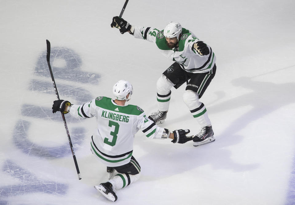 Dallas Stars' John Klingberg (3) and Jamie Benn (14) celebrate a goal against the Calgary Flames during overtime in Game 4 of an NHL hockey first-round playoff series, Sunday, Aug. 16, 2020, in Edmonton, Alberta. (Jason Franson/The Canadian Press via AP)
