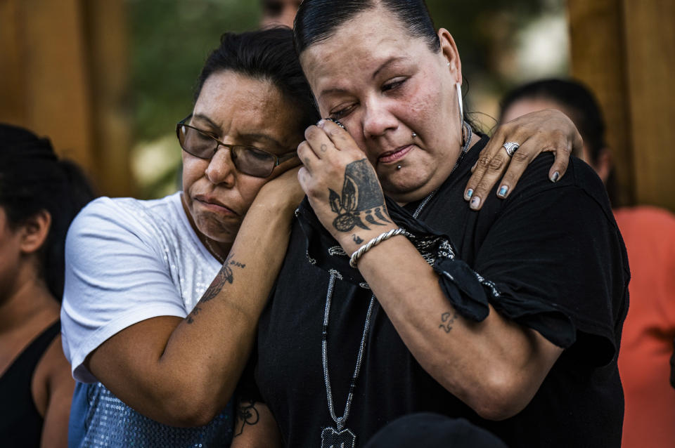 Friend Alicia Smith,left, comforts Melissa Waukazo, the sister of William "Billy" Hughes after a ceremony for her brother on Monday, Aug. 6, 2018 in St. Paul, Minn. The Bureau of Criminal Apprehension said in a statement Tuesday, Aug. 7, that William James Hughes, 43, died of multiple gunshot wounds early Sunday after officers responded to a 911 call of multiple shots fired on the upper floor of the apartment building where he lived. (Richard Tsong-Taatarii/Star Tribune via AP) /Star Tribune via AP)