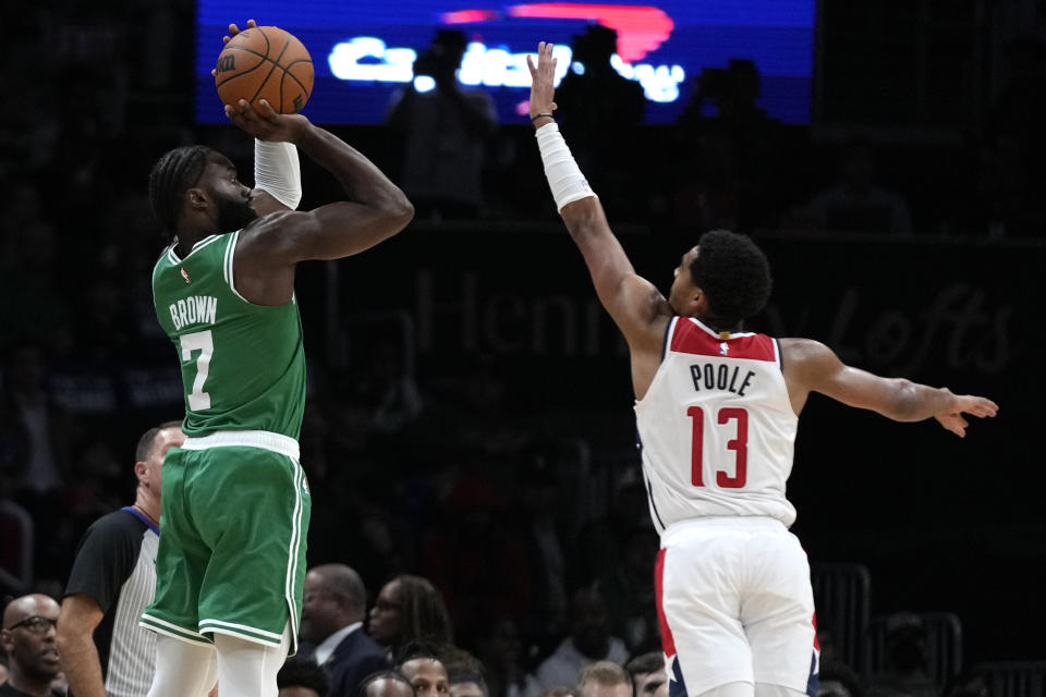 Boston Celtics guard Jaylen Brown (7) shoots over Washington Wizards guard Jordan Poole (13) during the first half of an NBA basketball game Monday, Oct. 30, 2023, in Washington. (AP Photo/Mark Schiefelbein)