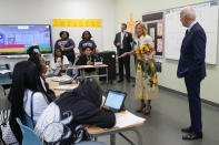 President Joe Biden listens as first lady Jill Biden speaks with students at Eliot-Hine Middle School on Monday, Aug. 28, 2023, in Washington. The Bidens visited the school, located east of the U.S. Capitol, to mark the District of Columbia's first day of school for the 2023-24 year. (AP Photo/Manuel Balce Ceneta)