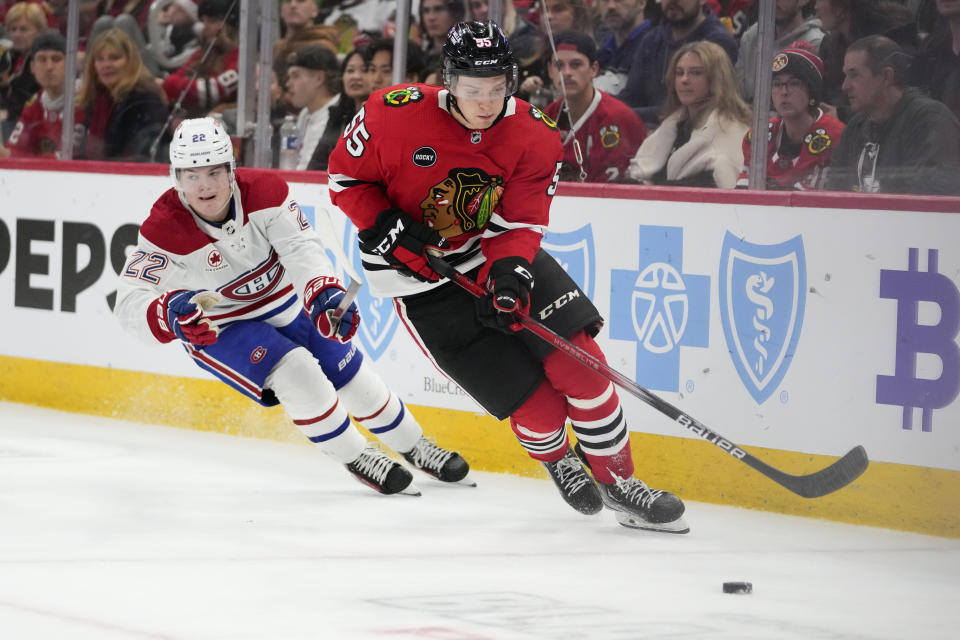 Chicago Blackhawks defenseman Kevin Korchinski, right, and Montreal Canadiens right wing Cole Caufield chase the puck during the third period of an NHL hockey game Friday, Dec. 22, 2023, in Chicago. (AP Photo/Erin Hooley)