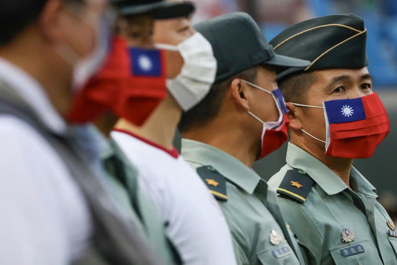 Army representative are seen at the opening of a baseball game with face masks decorated as a Taiwan flag to protect themselves from the coronavirus disease (COVID-19) at a professional baseball league game at Taoyuan International baseball stadium