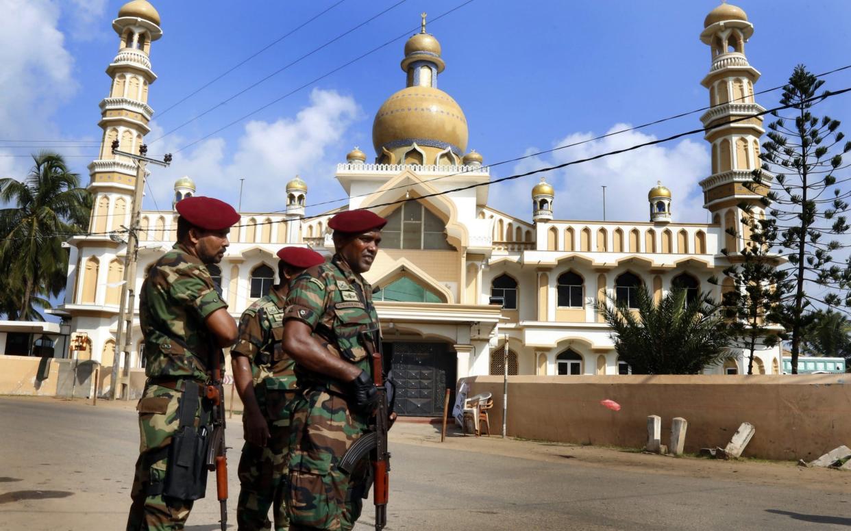 Sri Lankan security personnel stand guard after the clashes erupted between the two communities in Negombo near Colombo - REX