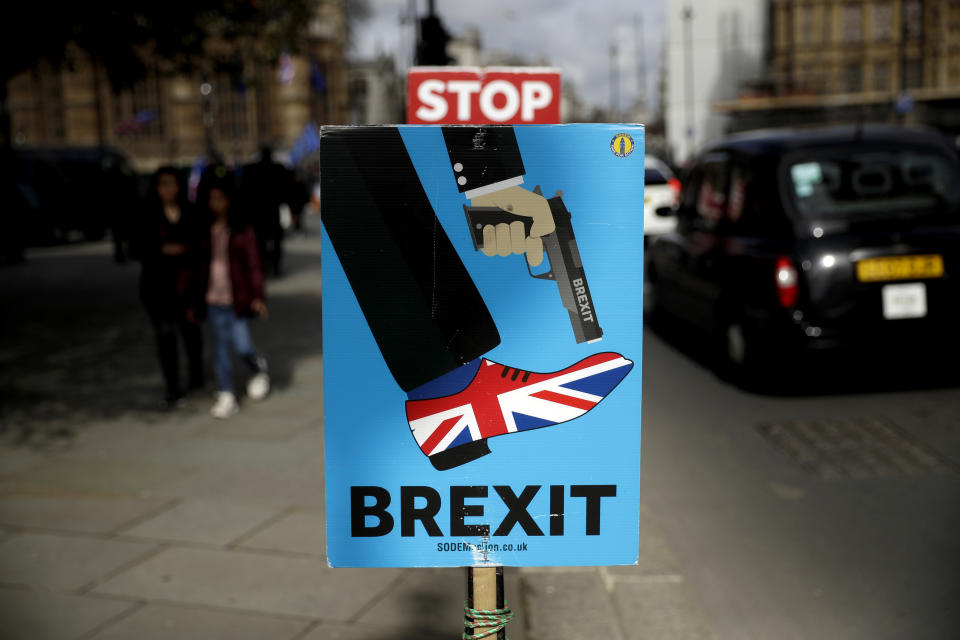 Placards placed by anti-Brexit supporters stand opposite the Houses of Parliament in London, Monday, March 18, 2019. British Prime Minister Theresa May was making a last-minute push Monday to win support for her European Union divorce deal, warning opponents that failure to approve it would mean a long — and possibly indefinite — delay to Brexit. Parliament has rejected the agreement twice, but May aims to try a third time this week if she can persuade enough lawmakers to change their minds. (AP Photo/Matt Dunham)