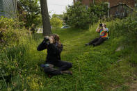 Avian ecologist and Georgetown University Ph.D. student Emily Williams, right, and a volunteer watch bird netting with binoculars from distance for American robins, Wednesday, April 28, 2021, in Cheverly, Md. (AP Photo/Carolyn Kaster)