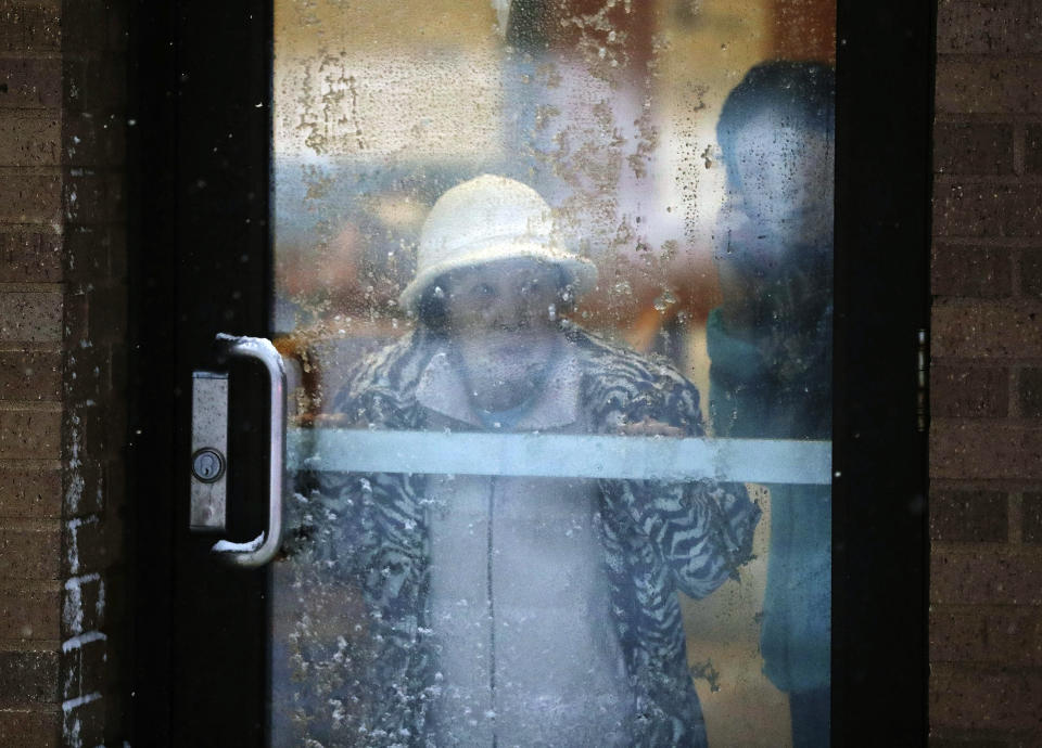 A displaced resident looks out a door after a deadly fire at a high-rise apartment building Wednesday, Nov. 27, 2019, in Minneapolis. (David Joles/Star Tribune via AP)