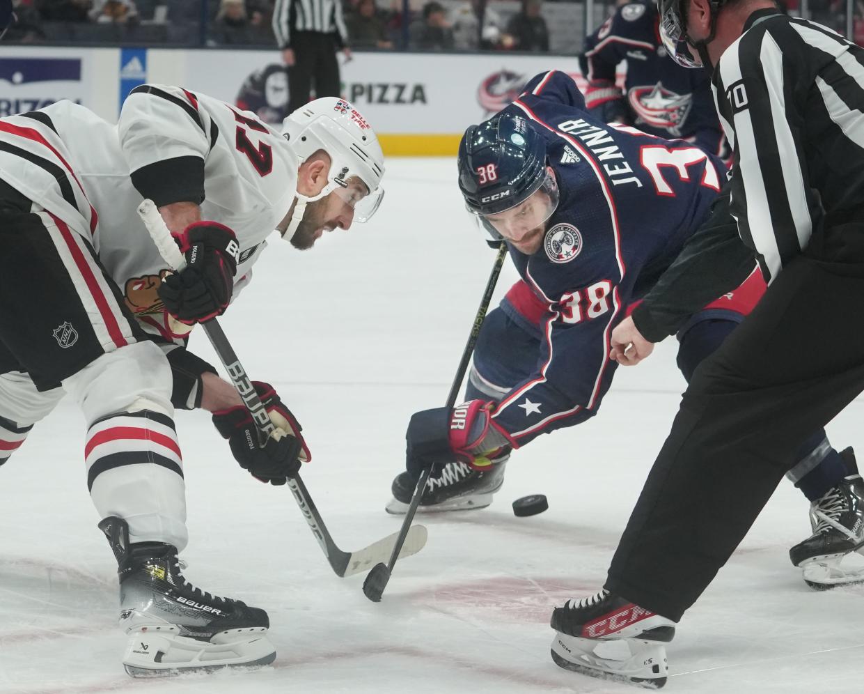 Nov 22, 2023; Columbus, Ohio, USA; Chicago Blackhawks left wing Nick Foligno (17), a former Blue Jackets captain, and current Blue Jackets captain Boone Jenner (38) faceoff during the first period of the NHL hockey game at Nationwide Arena in Columbus on November 22, 2023.