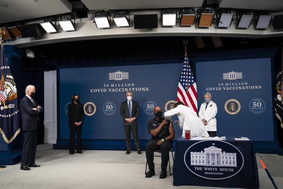 President Joe Biden looks on as Washington DC firefighter and EMT Gerald Burn receives a vaccination, during an event to commemorate the 50 millionth COVID-19 shot, in the South Court Auditorium on the White House campus, Thursday, Feb. 25, 2021, in Washington. From left, Biden, Vice President Kamala Harris, White House COVID-19 Response Coordinator Jeff Zients, Burn, registered nurse Elizabeth Galloway, and director of the National Institute of Allergy and Infectious Diseases Dr. Anthony Fauci. (AP Photo/Evan Vucci)