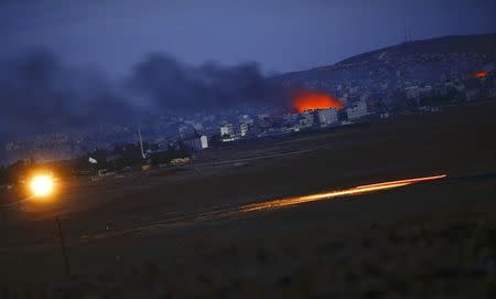 Smoke and flames rise over Syrian town of Kobani after an airstrike, as seen from the Mursitpinar border crossing on the Turkish-Syrian border in the southeastern town of Suruc in Sanliurfa province, October 18, 2014. REUTERS/Kai Pfaffenbach