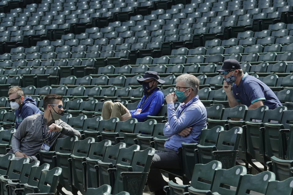 FILE - Seattle Mariners general manager Jerry Dipoto, second from left, manager Scott Servais, right, and team president and CEO Kevin Mather, second from right, watch from the stands during baseball practice in Seattle, in this July 8, 2020, file photo. Seattle Mariners general manager Jerry Dipoto and manager Scott Servais are doing damage control with players who were directly mentioned or referenced by former team CEO Kevin Mather in an online video that led to his resignation. (AP Photo/Ted S. Warren, File)