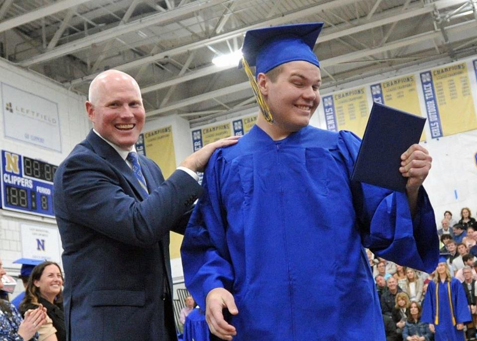 Owen Casagrande, right, admires his diploma after receiving it from Principal Marc Bender.
