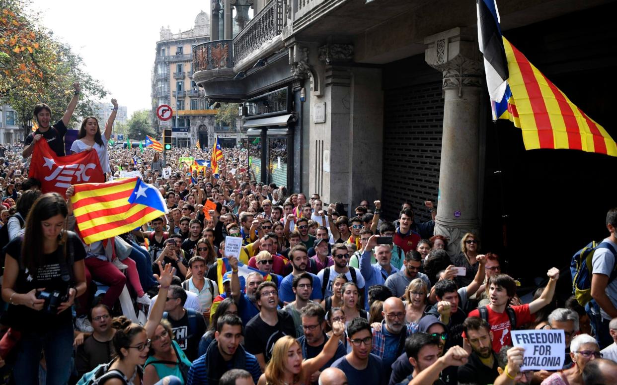 Protesters wave Catalan pro-independence flags during a march outside the regional economy ministry  - AFP