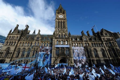 Manchester City players stand with their manager Roberto Mancini as they celebrate becoming English Premier League champions in a parade leaving from Manchester Town Hall