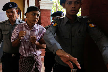 Detained Reuters journalist Kyaw Soe Oo is escorted by police while leaving after a court hearing in Yangon, Myanmar May 21, 2018. REUTERS/Ann Wang