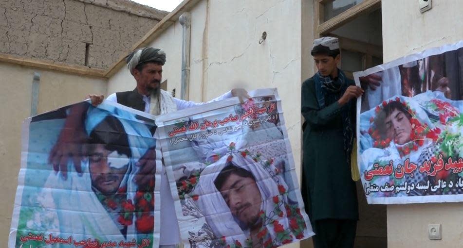 Minhajuddin (left), an Afghan who says he was arrested in a night raid by U.S. forces in 2010 in Afghanistan's Wardak Province, is helped to hold up photos of his three sons whom he says were killed in the raid. / Credit: CBS News