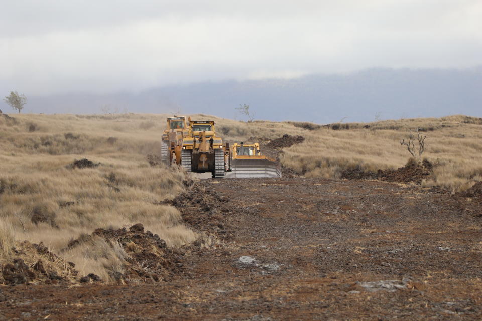 This photo provided by the Hawaii Department of Land and Natural Resources shows bulldozers in the area of a large wildfire on Thursday, Aug. 11, 2022, in a rural area of Hawaii's Big Island is not threatening any homes, but high winds and extremely dry conditions are making it difficult for crews to contain the blaze. (Hawaii Department of Land and Natural Resources via AP)