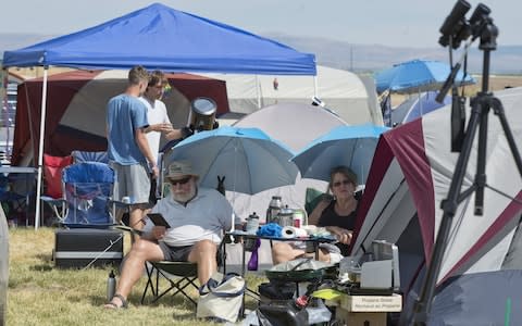 Visitors wait and adjust telescopes Solartown in Madras, Oregon  - Credit: Barcroft Media