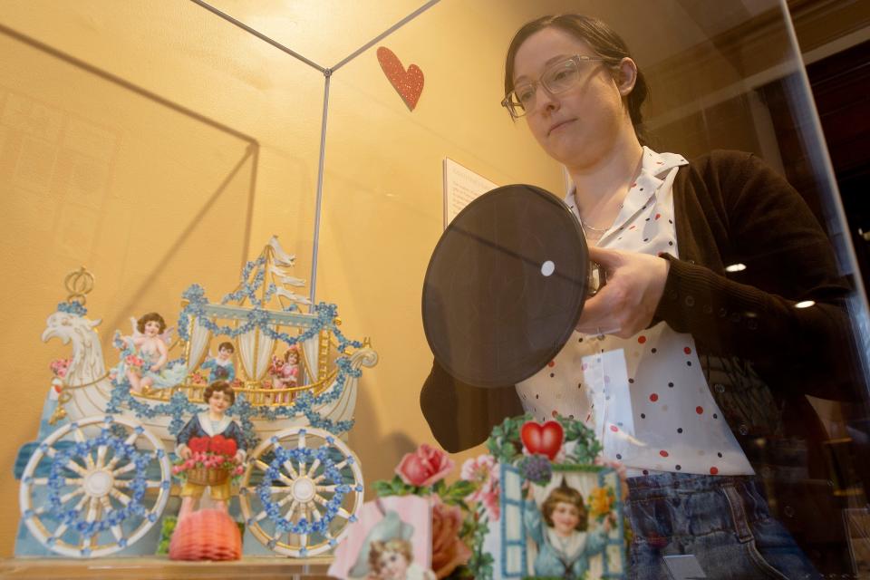 On Feb. 2, Curatorial Assistant Amanda Rockwood covers with translucent protection the old-time Valentine's card display at the Hagen History Center. Rockwood, formed part of the team with Staton and Weiser, who selected the cards on display, some of which date back to the 1830s.