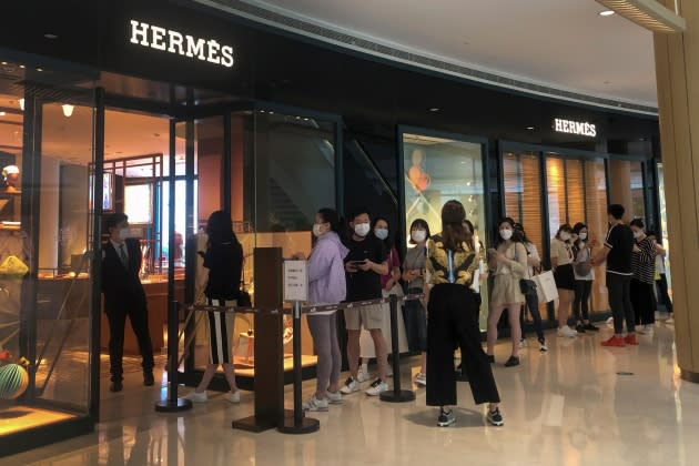 People line up in front of a Louis Vuitton store in Shanghai