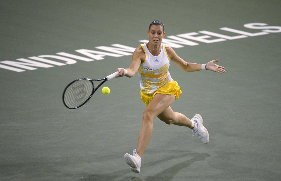 Flavia Pennetta, of Italy, eturns a shot to Li Na, of China, at the BNP Paribas Open tennis tournament, Friday, March 14, 2014, in Indian Wells, Calif. (AP Photo/Mark J. Terrill)