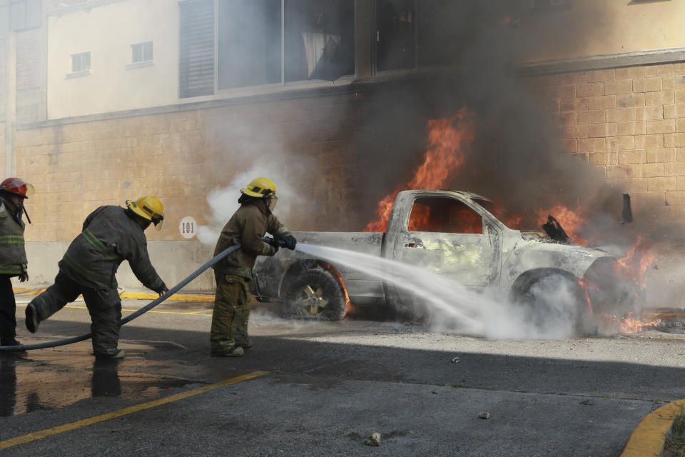 Firefighters put out a fire where a truck was set fire by rural teachers' college students protesting the previous month's shooting of one of their classmates during a confrontation with police, outside the municipal government palace in Chilpancingo, Mexico, Monday, April 8, 2024. (AP Photo/Alejandrino Gonzalez)