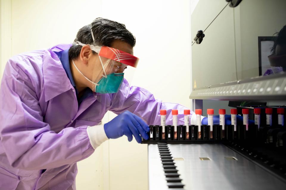 Charles Chiu, MD, PhD, director of the UCSF-Abbott Viral Diagnostics and Discovery Center, inserts a tray of Universal Transport Medium (UTM) or vials for the collection, transport, maintenance and long term freeze storage of viruses into a Biomatrix sorter that the Chiu Lab will be using, starting Monday to study the genes of the Coronavirus.