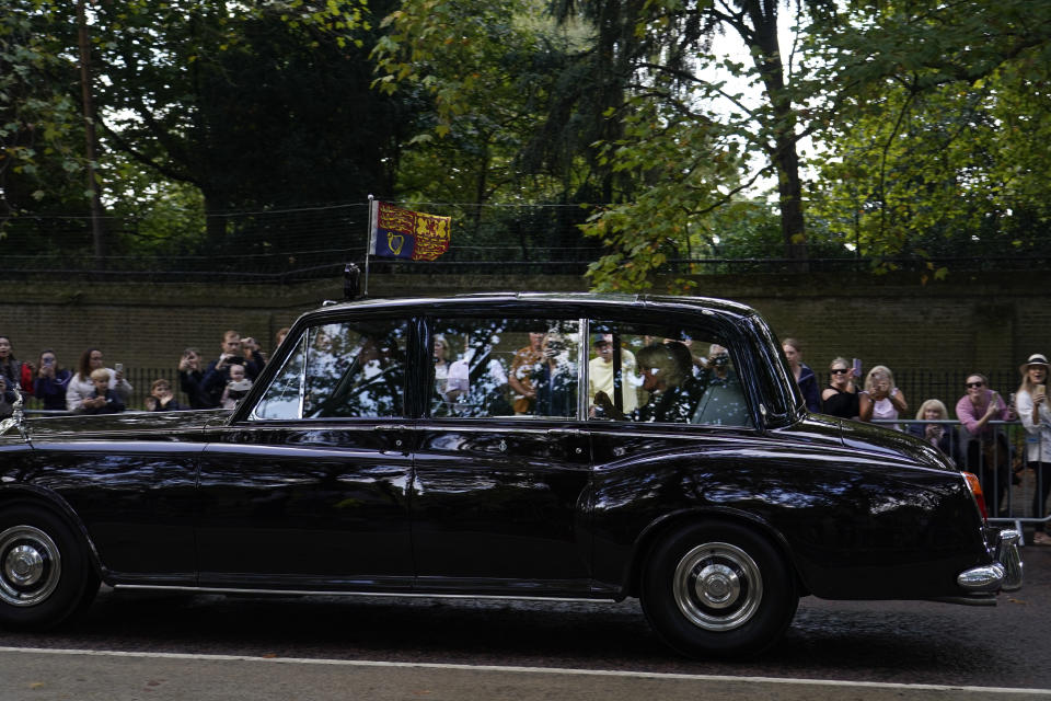 The car carrying King Charles III and Camilla, the Queen Consort, heads to Buckingham Palace in London, Friday, Sept. 9, 2022. Queen Elizabeth II, Britain's longest-reigning monarch and a rock of stability across much of a turbulent century, died Thursday Sept. 8, 2022, after 70 years on the throne. She was 96. (AP Photo/Alberto Pezzali)