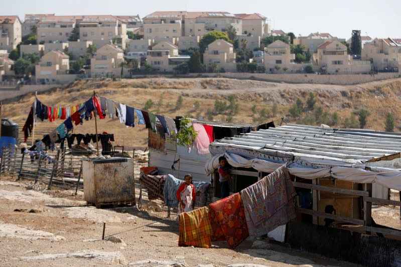 FILE PHOTO: Palestinian children play outside their dwelling in al-Eizariya town with the Jewish settlement of Maale Adumim in the background, in the Israeli-occupied West Bank