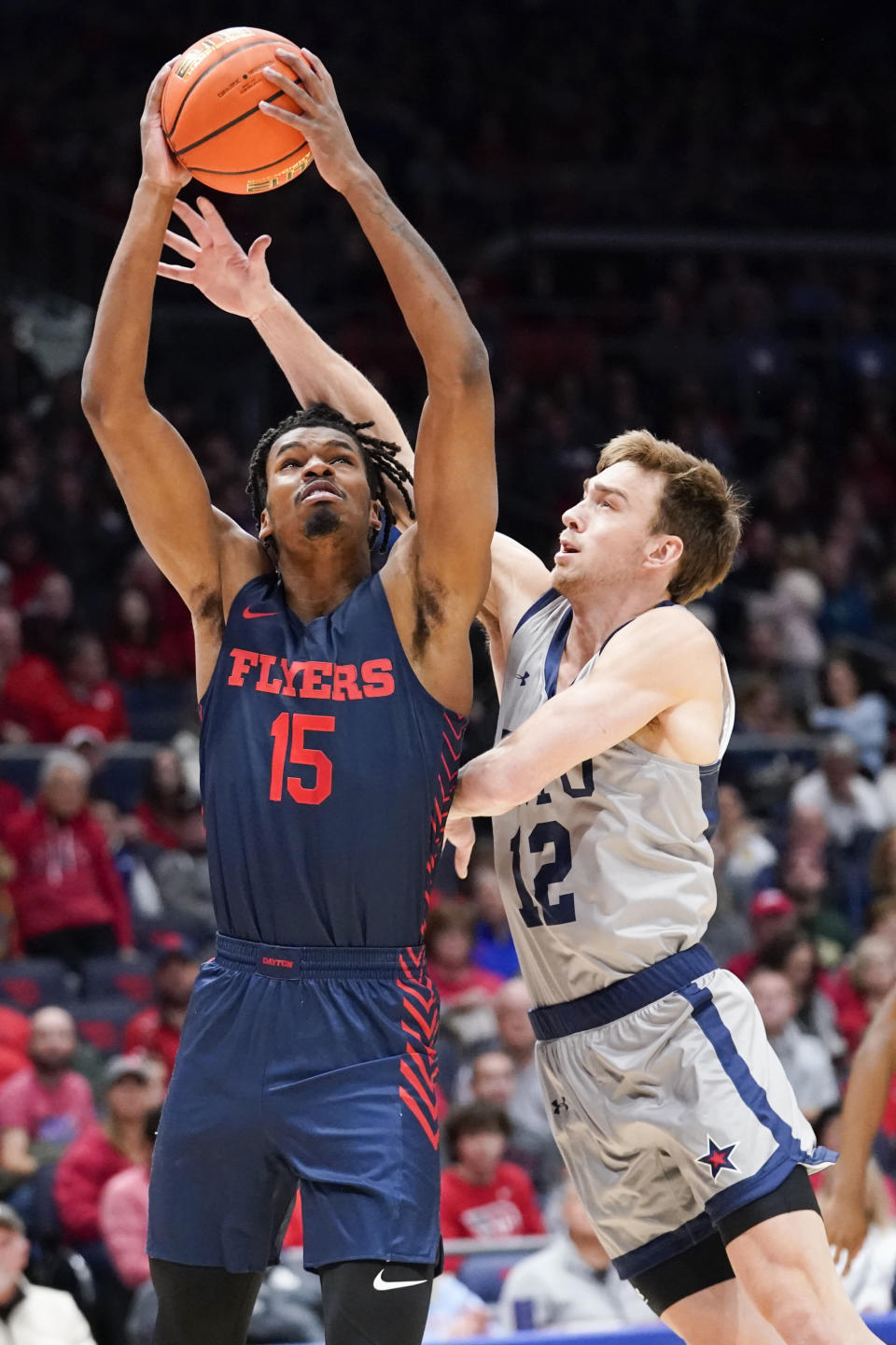 Dayton forward DaRon Holmes II (15) jumps to the basket for a layup as Robert Morris guard Jackson Last (12) fouls during the first half of an NCAA college basketball game, Saturday, Nov. 19, 2022, in Dayton, Ohio. (AP Photo/Joshua A. Bickel)