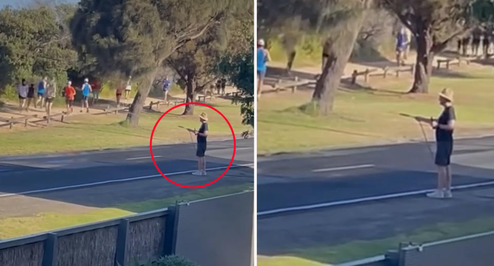 Man wearing hat holding beer hosing down runners on other side of the road. 