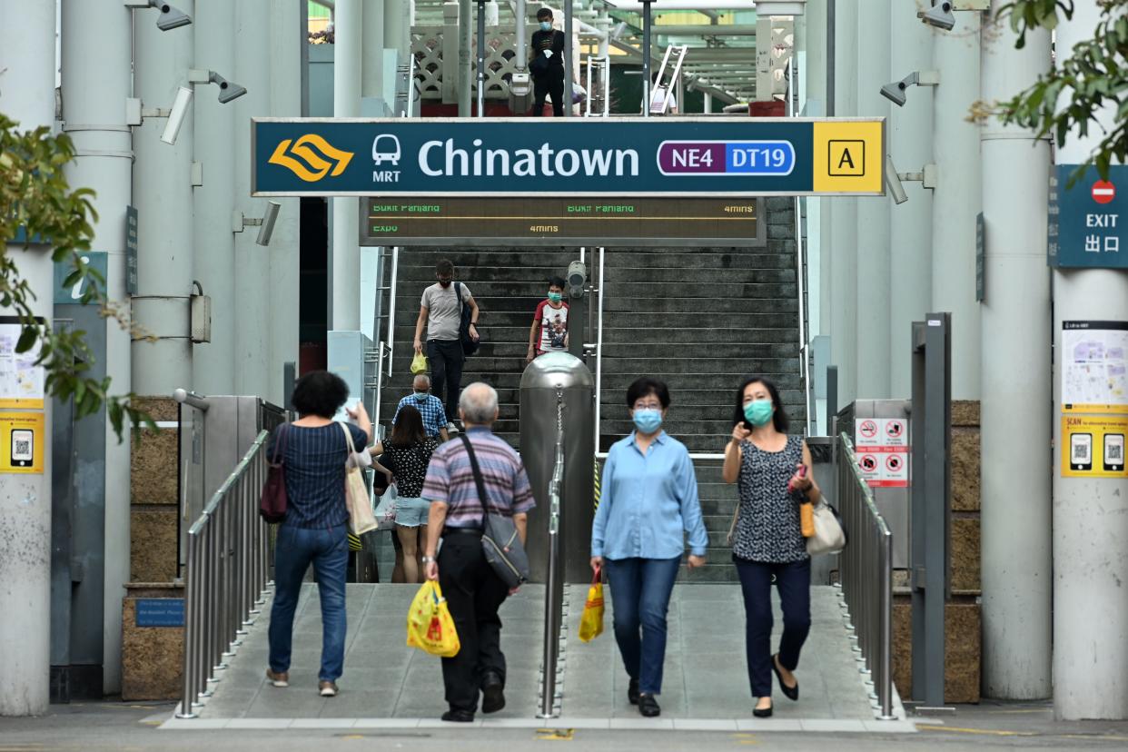 People walk in and out of the Singapore Mass Rapid Transit station in the Chinatown district in Singapore on June 12, 2020, as the city state eased its partial lockdown restrictions aimed at curbing the spread of the COVID-19 coronavirus. (Photo by ROSLAN RAHMAN / AFP) (Photo by ROSLAN RAHMAN/AFP via Getty Images)