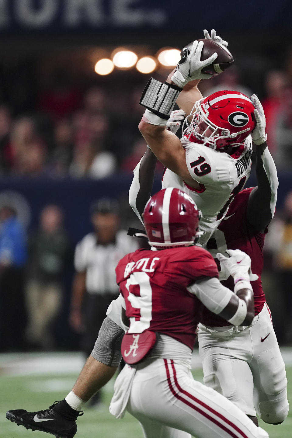 Georgia tight end Brock Bowers (19) makes ther catch against Alabama defensive back Jordan Battle (9) during the second half of the Southeastern Conference championship NCAA college football game, Saturday, Dec. 4, 2021, in Atlanta. (AP Photo/John Bazemore)