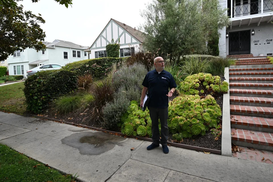 Los Angeles Department of Water and Power (LADWP) Water Conservation Specialist Damon Ayala finds water leaking onto the pavement from a landscape irrigation system, while patrolling a residential neighbor in search of illegal lawn irrigation and irrigation leakage, July 6, 2022 during California's historic drought. - Damon Ayala patrols the streets of drought-struck Los Angeles every day, inspecting the sidewalks. Each time he sees a puddle, he stops. 