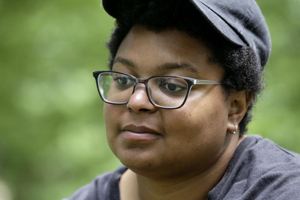 In this May 15, 2018, photo, activist Maya Little takes an interview near the Silent Sam Confederate statue on campus at the University of North Carolina in Chapel Hill, N.C. Little, a UNC-Chapel Hill graduate student at the forefront of protests over a Confederate statue on campus, has been arrested again. News outlets report authorities say 26-year-old Maya Little is charged with inciting a riot and assaulting an officer during a rally Monday, Dec. 3. (AP Photo/Gerry Broome)