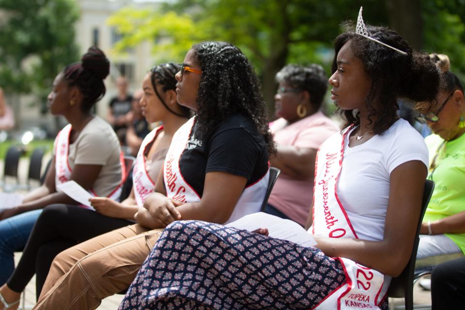 Shontal Phillips, right, this year's Miss Juneteenth Queen, listens with other pageant winners to presenters at Monday's Juneteenth event at the Statehouse.