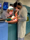 In this photo provided by Bassam Osman, Dr. Bassam Osman, a 27-year-old surgical resident, right, attends a surgical operation under the supervision of his mentor Dr. Jamil Borgi, left, in Beirut Lebanon, September 3, 2020. It was a night Osman says changed his life. At around 6 p.m. on Aug. 4, he was about to leave his daily hospital shift when a massive explosion shook Beirut. (Bassam Osman via AP)