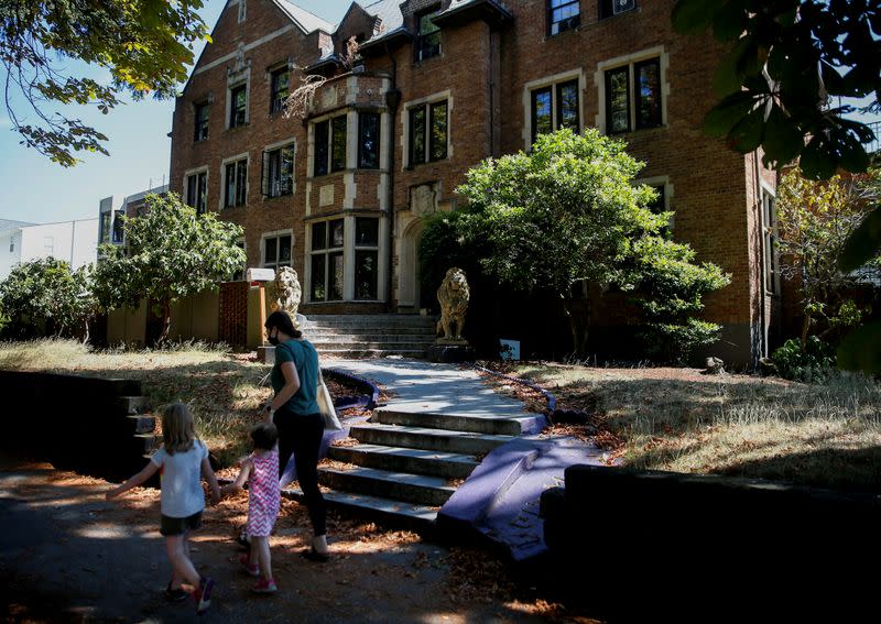 People walk by a fraternity house in the Greek Row area at the University of Washington in Seattle