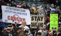Dec 24, 2015; Oakland, CA, USA; Spectators hold signs reading "Stay in Oakland" and "Stay in San Diego" in reference to the San Diego Chargers and the Oakland Raiders proposed move to Los Angeles during an NFL football game at O.co Coliseum. Mandatory Credit: Kirby Lee-USA TODAY Sports