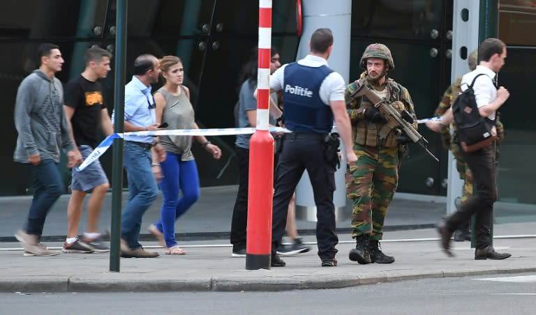 Soldiers and police officials guide members of the public outside Gare Centrale in Brussels on June 20, 2017