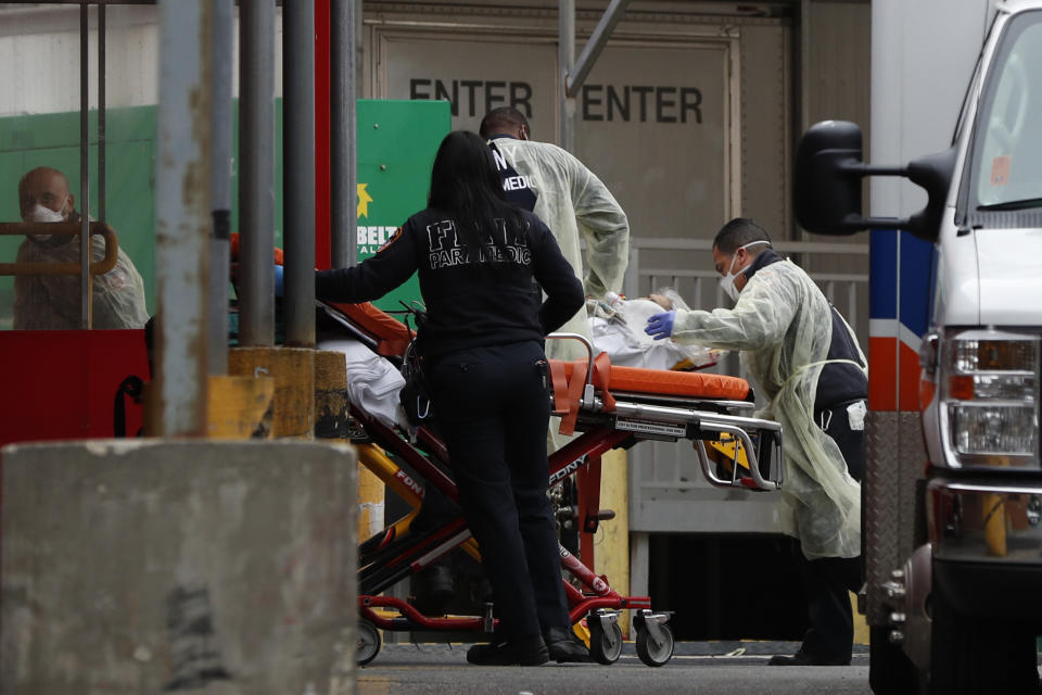 An elderly patient is wheeled into the emergency entrance to Elmhurst Hospital Center in New York, Saturday, March 28, 2020. The hospital is caring for a high number of coronavirus patients in the city. (AP Photo/Kathy Willens)