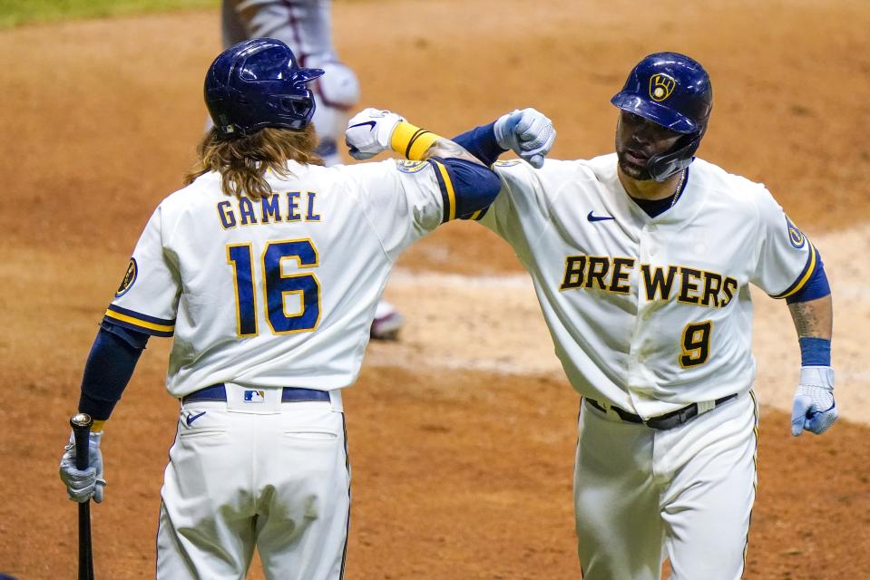 Milwaukee Brewers' Manny Pina is congratulated by Ben Gamel after hitting a two-run home run during the sixth inning of a baseball game against the Minnesota Twins Tuesday, Aug. 11, 2020, in Milwaukee. (AP Photo/Morry Gash)