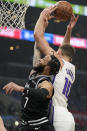 Sacramento Kings forward Domantas Sabonis, right, grabs a rebound away from Los Angeles Clippers guard Amir Coffey during the first half of an NBA basketball game Saturday, Dec. 3, 2022, in Los Angeles. (AP Photo/Mark J. Terrill)