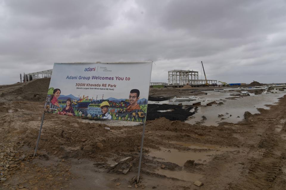 A sign is displayed at the construction site of Adani Green Energy Limited's Renewable Energy Park in the salt desert of Karim Shahi village, near Khavda, Bhuj district near the India-Pakistan border in the western state of Gujarat, India, Thursday, Sept. 21, 2023. India is developing a 30 gigawatt hybrid — wind and solar — renewable energy project on one of the largest salt deserts in the world. (AP Photo/Rafiq Maqbool)