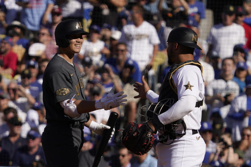 American League designated hitter Shohei Ohtani, left, of the Los Angeles Angels, is greeted by National League's catcher Wilson Contreras, of the Chicago Cubs, before taking an at bat during the first inning of the MLB All-Star baseball game, Tuesday, July 19, 2022, in Los Angeles. (AP Photo/Mark J. Terrill)