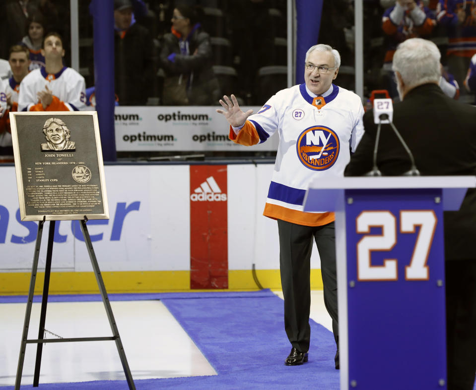 Former New York Islander John Tonelli waves to his former teammates as he enters the ice for his jersey retirement ceremony, Friday, Feb. 21, 2020, in Uniondale, N.Y. (AP Photo/Kathy Willens)