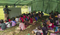 A woman teaches internally displaced children at Pu Phar Village, Demawso Township, Kayah State on Thursday June 17, 2021. A report on the situation in conflict-affected areas of Myanmar issued this week by the U.N.'s Office for the Coordination of Humanitarian Affairs says around 108,800 people from Kayah State were internally displaced following an escalation of hostilities between the government military and the local Karenni People's Defense Force militia since the coup Feb. 1, 2021. (AP Photo)