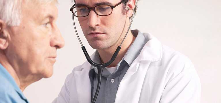 Doctor checking patient's heart with a stethoscope.